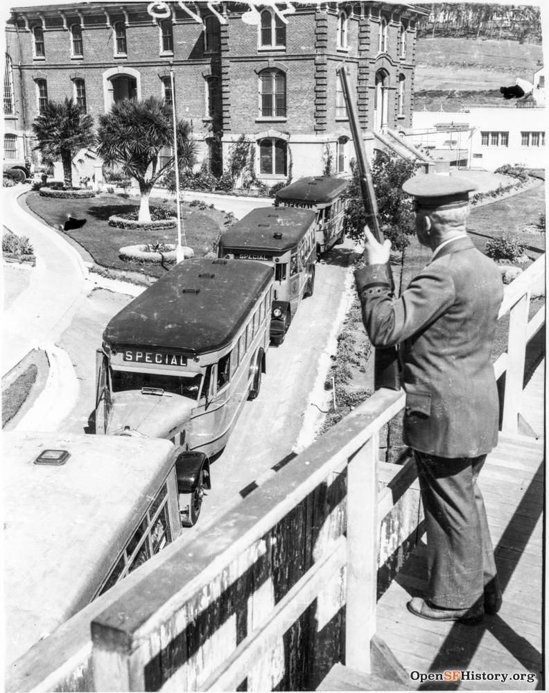 Prison buses leaving jail, guard with rifle watching. Ingleside Jail closed 8 July 1934. Prisoners were transferred under heavy guard to new county jail at San Bruno. Judson hillside in right background wnp4.1206.jpg