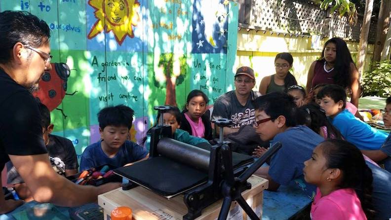 Jose Cruz screenprinting with children in Jardín Secreto.jpg