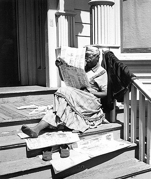 Woman-reading-newspaper-on-steps.jpg