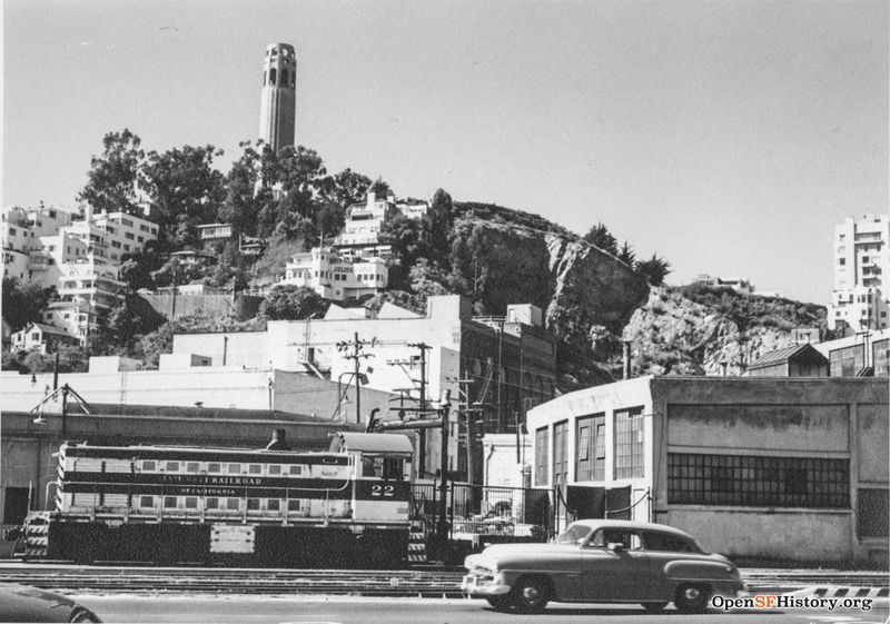 File:C1957 View west from The Embarcadero near Lombard toward Telegraph Hill. Belt Line locomotive 22 and Belt Line Railroad roundhouse at right, Julius Castle and Coit Tower in the background wnp27.3268.jpg
